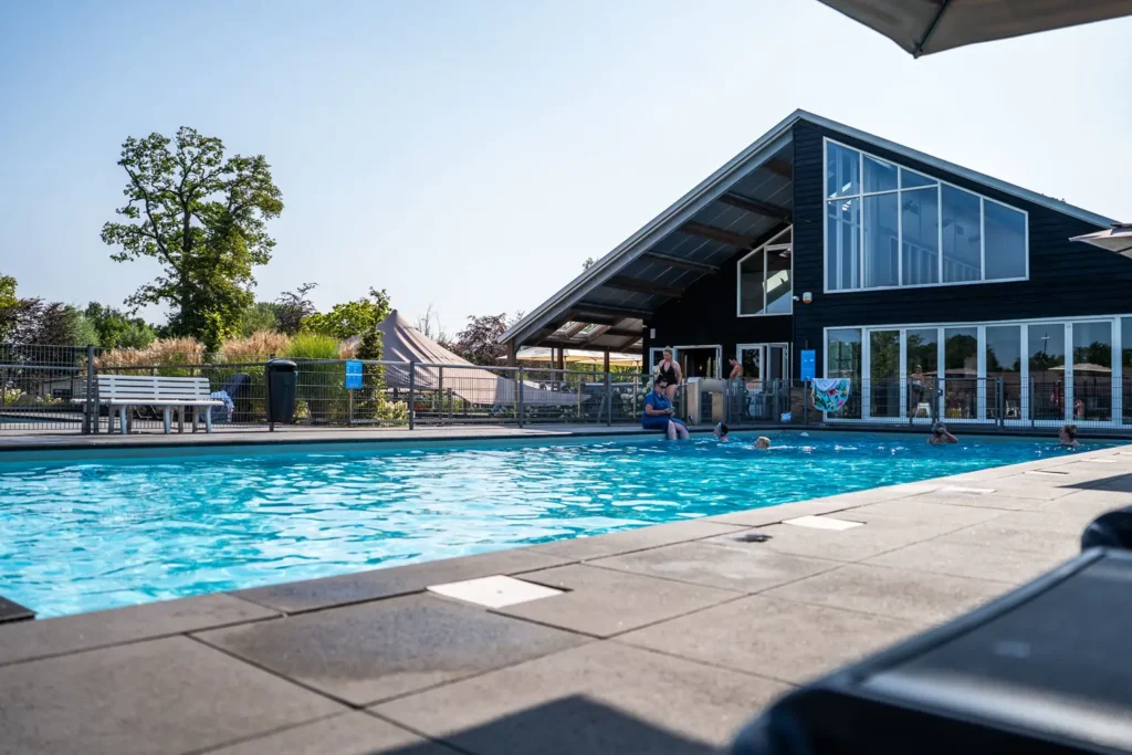 Het buitenzwembad met op de achtergrond het restaurant op residence lichtenvoorde